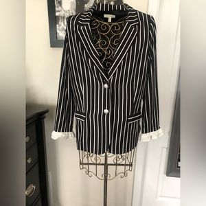 Black and white stripe suit. Blazer has ruffle sleeves.